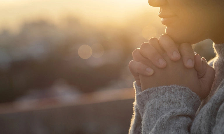 women with praying hands wearing Christian apparel 